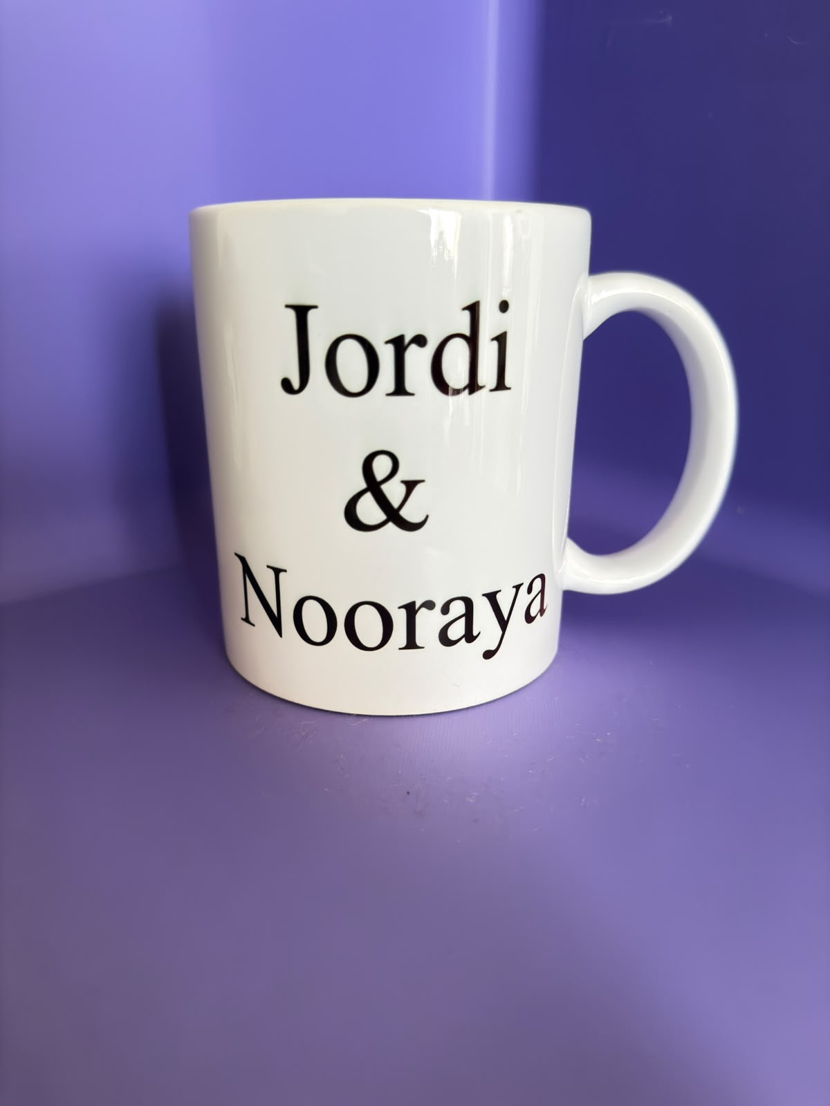 Witte mok met de namen Jordi en Nooraya in zwarte letters.